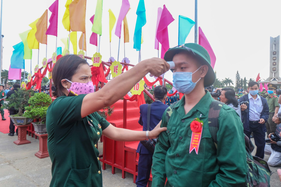 Cán bộ Quân y kiểm tra thân nhiệt cho thanh niên trước khi lên xe về với đơn vị đóng quân. Cán bộ Quân y kiểm tra thân nhiệt cho thanh niên trước khi lên xe về với đơn vị đóng quân.