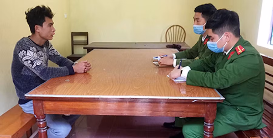 Đặng Xuân Trụ (bên trái) tại cơ quan Công an