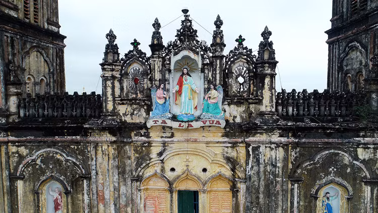 Bức tượng chúa Giêsu Vua trên đỉnh nhà thờ cũ dự kiến sẽ được đưa sang vị trí tương tự ở nhà thờ mới. Ảnh: Giang Huy.