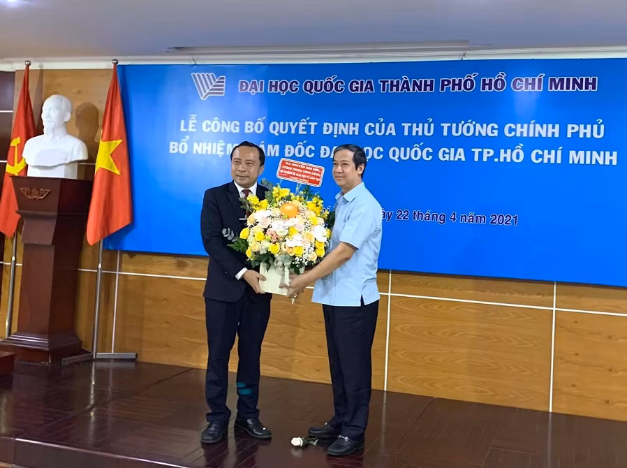 Bộ trưởng Bộ GD&amp;ĐT Nguyễn Kim Sơn (phải) trao hoa chúc mừng Giám đốc ĐHQG TP.HCM