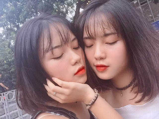 2 nữ sinh tỏa sáng trong bộ đồng phục của trường với áo trắng tinh khôi, mái tóc ngắn chấm vai và giống nhau như hai giọt nước.