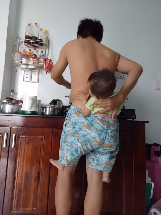 Ông bố trẻ địu con trong quần để rảnh tay nấu ăn trong lúc vợ bệnh khiến chị em cười ngất - Ảnh 3.