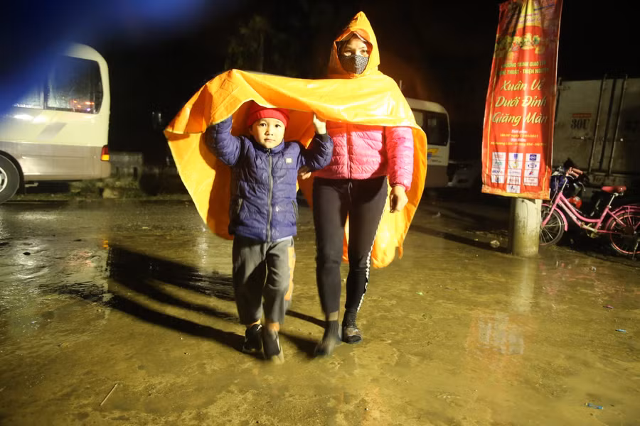 Người dân không quản mưa lớn vẫn mặc áo mưa đến xem chương trình nghệ thuật .