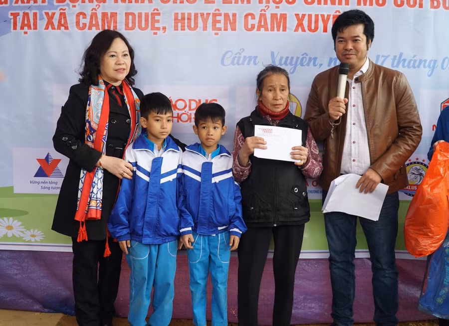 Thư trưởng Ngô Thị Minh (bên trái) trao quà cho 3 bà cháu.