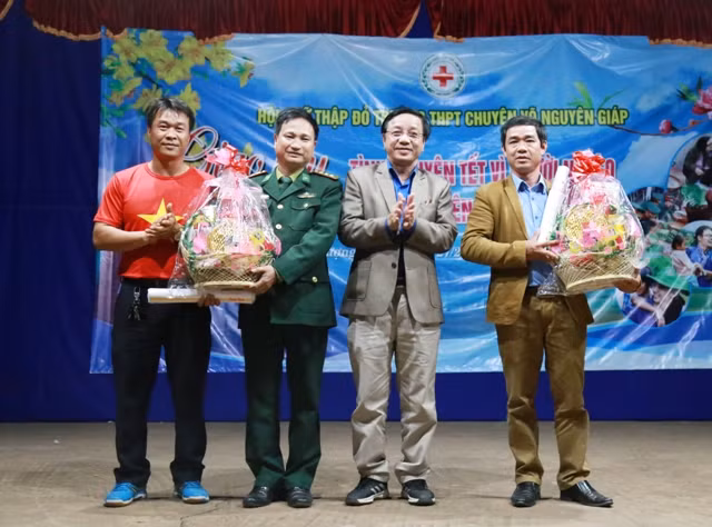 Thầy giáo Hoàng Thanh Cảnh, hiệu trưởng trường THPT chuyên Võ Nguyên Giáp tặng quà cho trường PTDT nội trú và Đồn Biên Phòng Cồn Roàng đóng tại xã Thượng Trạch.