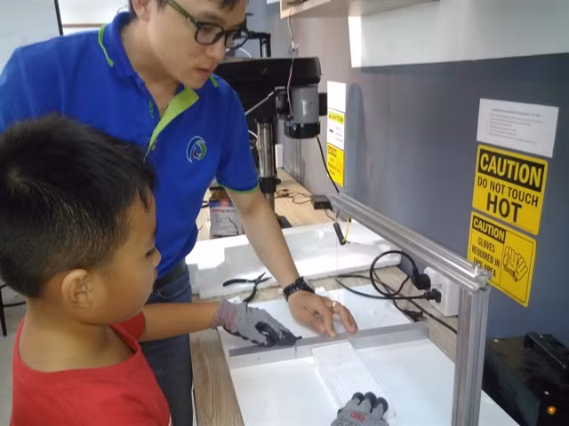 Một bạn HS đang thực hiện việc cắt miếng xốp trên dây kim loại dẫn nhiệt.