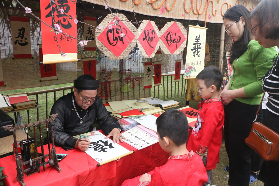 Một góc gian hàng của ông Đồ viết tranh chữ thư pháp cho cả phụ huynh và trẻ nhỏ.