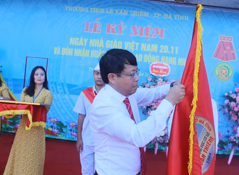 Gắn Huân chương Lao động hạng Nhất lên cờ truyền thống.