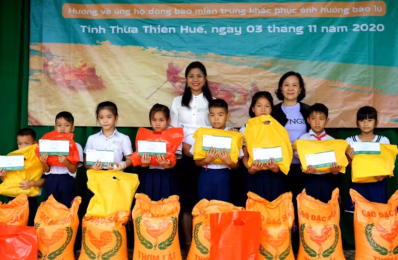 Tặng quà và tiền mặt cho các em học sinh.