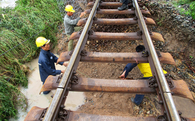 Nước lũ cuốn trôi phần móng đường sắt đoạn qua tỉnh Ninh Thuận làm tuyến đường sắt Bắc - Nam tê liệt. Ảnh:Tuấn Kiệt. Bao so 9 van vu giat sap nhieu nha, giao thong chia cat hinh anh 1