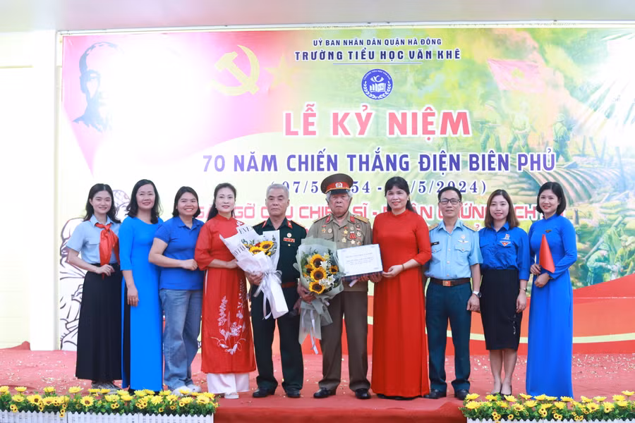 Đại diện nhà trường chụp ảnh lưu niệm cùng các cựu chiến binh.