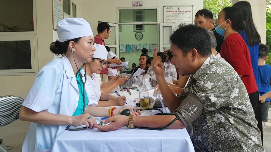 Bà Nguyễn Băng Hải - Trạm trưởng Trạm Y tế Hạ Đình trực tiếp thăm khám cho người dân. Ảnh: TG.