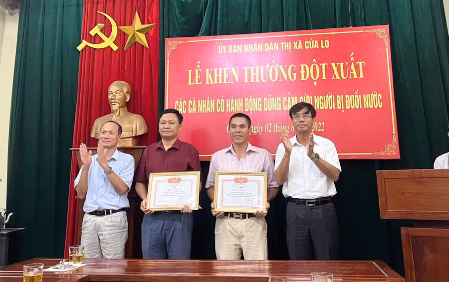 UBND thị xã Cửa Lò trao giấy khen cho ông Nguyễn Văn Trung - Bí thư Đảng ủy phường Nghi Hải (thứ 2 bên trái) và ông Nguyễn Trường Trung (thứ 2 bên phải).