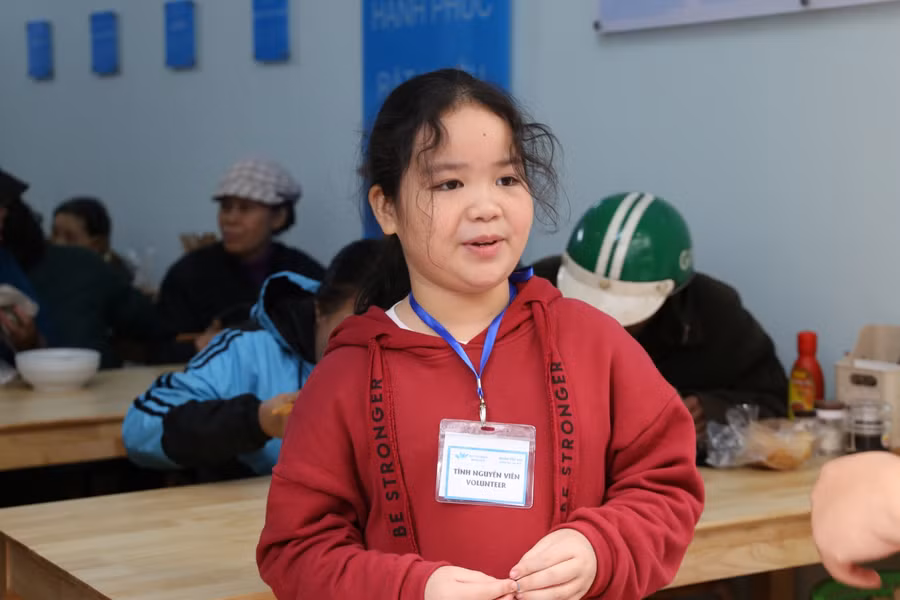 Tình nguyện viên nhí – con gái của anh Nguyễn Cao Sơn chủ quán ăn đang tiếp đón khách tại cửa.