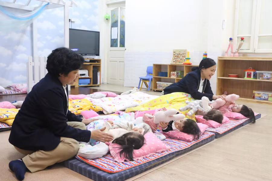 Các cô giáo chuẩn bị cho trẻ đi ngủ trưa tại lớp.