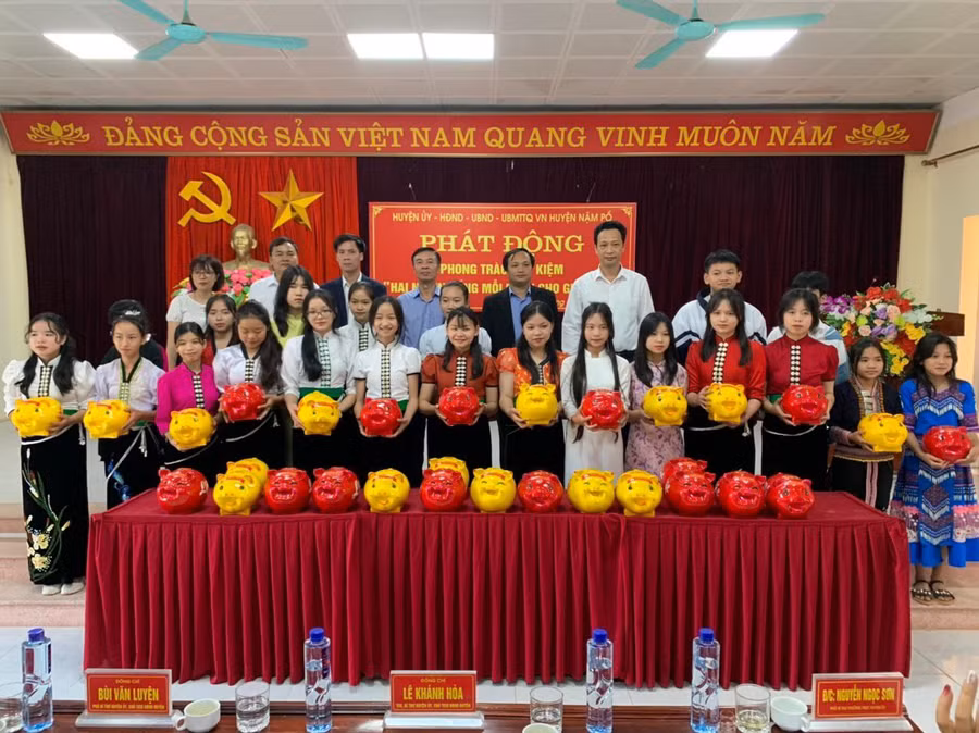 Lãnh đạo huyện Nậm Pồ cùng học sinh tại điểm cầu chính của Lễ phát động tiết kiệm.