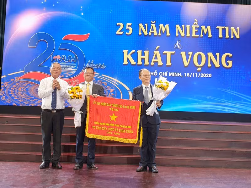 Lãnh đạo Trường ĐH Hùng Vương TP.HCM đón nhận cờ truyền tống của UBND TP.HCM trao tặng