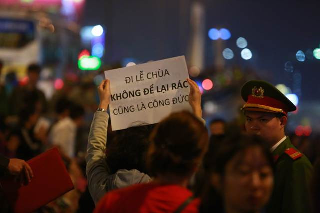 Nhiều bạn tình nguyện viên đã giơ cao tấm biển với khẩu hiệu đừng vứt rác khi đi lễ chùa