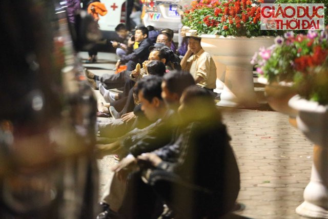 Phía bên ngoài rào sắt ngăn cách với khu vực sân Đền, hàng trăm người cũng đã ngồi kín, mắt nhìn vào bên trong. Nhiều người do quá mệt mỏi nên tranh thủ ngủ gục. Mùi hương khói, mùi mồ hôi váng vất không ngăn cản được du khách háo hức đợi chờ.