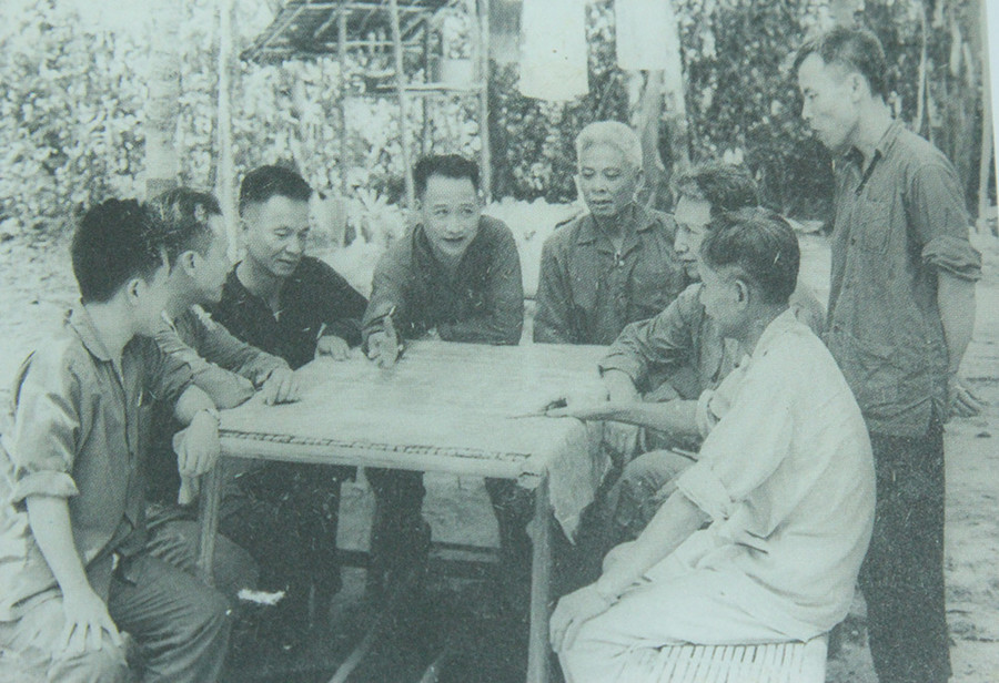 Trung tướng Trần Văn Trà - Tư lệnh Bộ Chỉ huy miền (người đang chỉ tay trên bản đồ) và Tham mưu trưởng Lê Đức Anh (người ngồi bên phải Trung tướng Trần Văn Trà) trong cuộc họp Bộ Chỉ huy miền tại căn cứ Lộc Ninh, tỉnh Bình Phước (R), năm 1972 Những hình ảnh quý về Đại tướng Lê Đức Anh thời kháng chiến