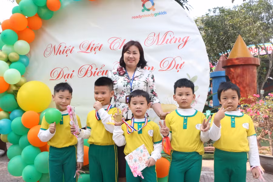 Cô Trần Thị Tâm - Hiệu trưởng Trường Mầm non Minh Khai và các bé tại trường.