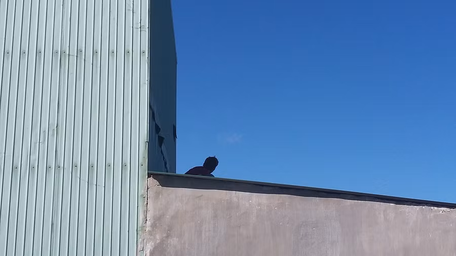 Nam thanh niên cố thủ trên mái nhà.