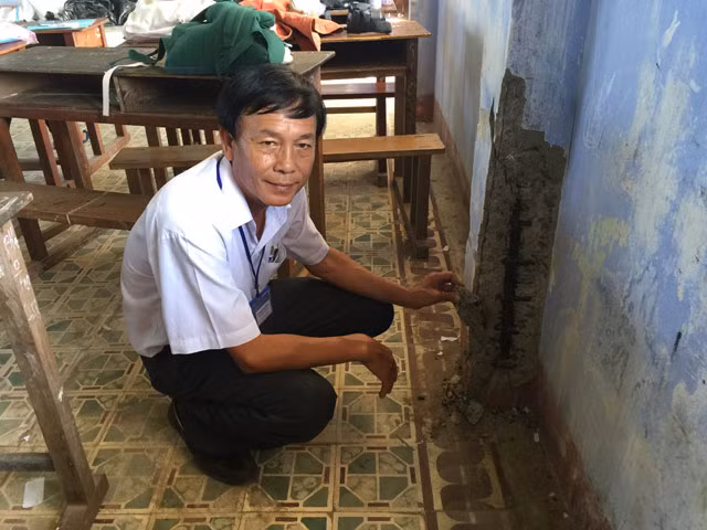 Thầy Huỳnh Văn Long bên trong phòng học xuống cấp