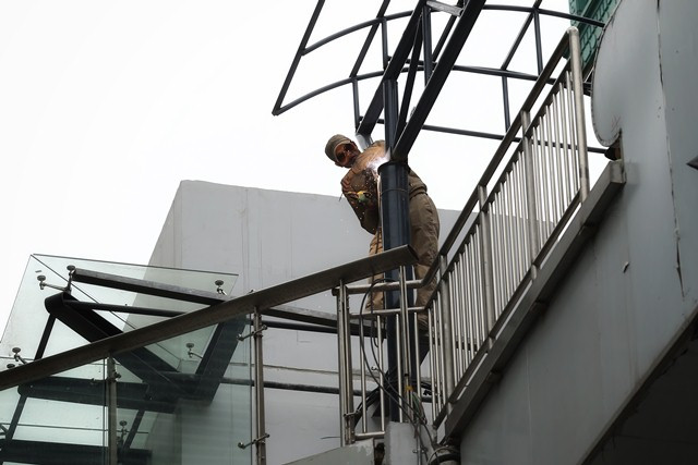 Công nhân đang hoàn thiện khung mái che cầu thang… Ảnh: Thế Đại Công nhân đang hoàn thiện khung mái che cầu thang… Ảnh: Thế Đại