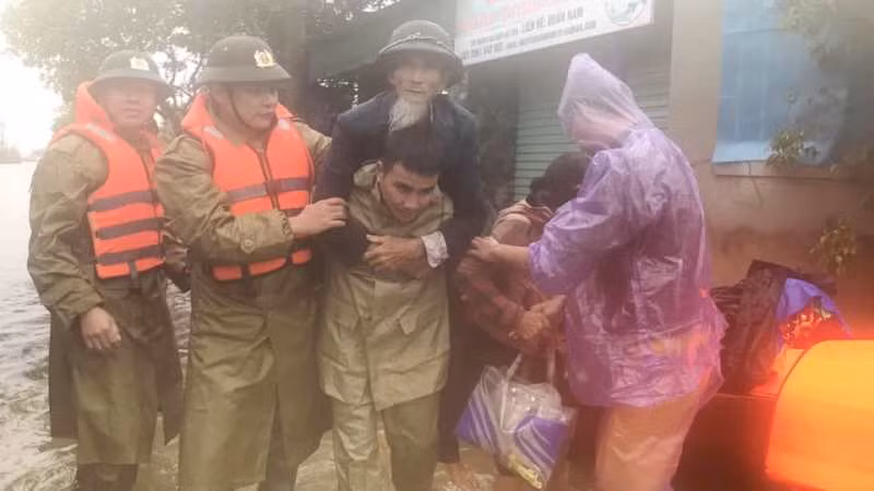 Lực lượng Công an huyện Thạch Hà cõng cụ ông 80 tuổi từ vùng lũ đến nơi an toàn.