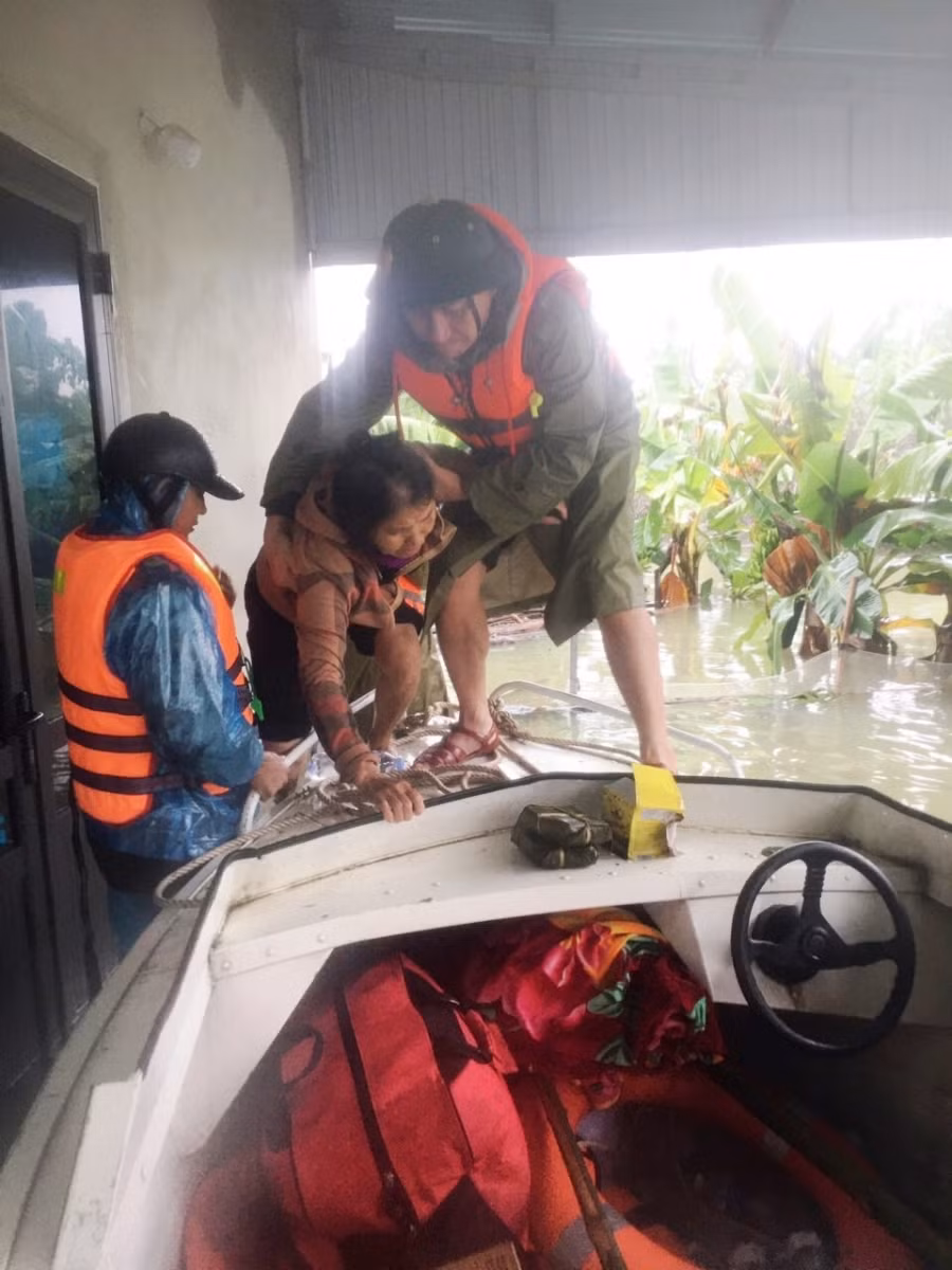 Đưa người dân lên cano sơ tán.