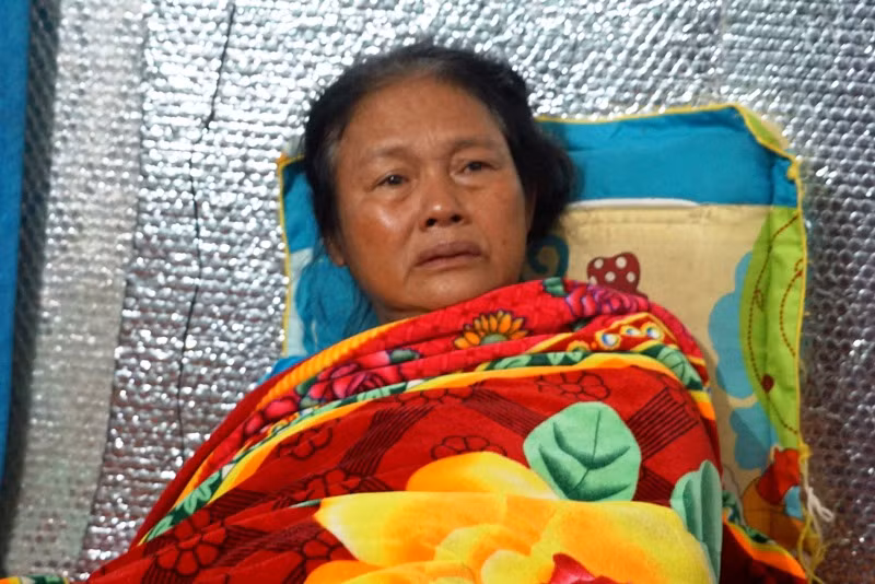 Bà Nguyễn Thị Tứ nằm trên giường, khóc gọi con trai trong đau đớn.