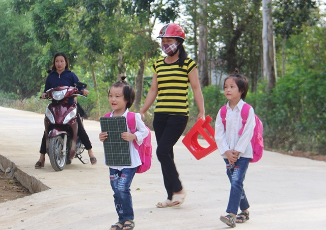 Các em được mẹ đưa đến trường đón ngày khai giảng.