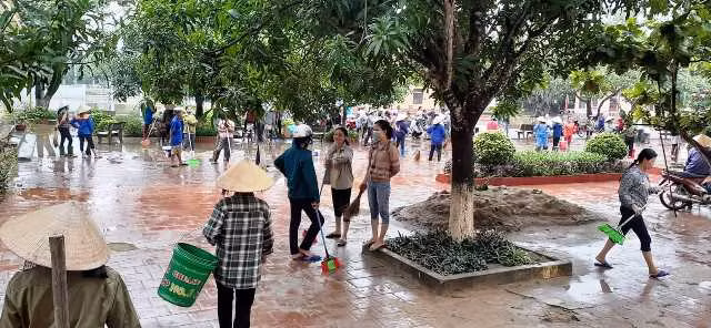 Dùng xô, chổi để tẩy sạch vết bẩn bám dính sau mưa lũ