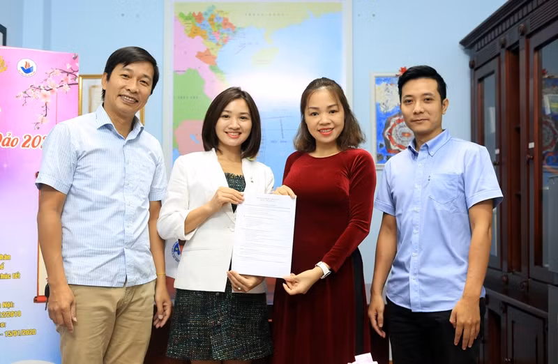 Nhóm tác giả "Nơi đầu sóng - Mắt trùng khơi" và Doanh nhân Cao Thị Thanh Nga (áo dài đỏ) trao biên bản hợp tác đồng hành vì biển đảo.