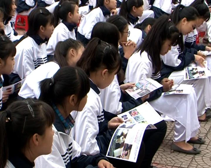 Học sinh trường THPT Lê Quý Đôn đang đọc tờ rơi tuyên truyền tác hại của chất ma túy.
