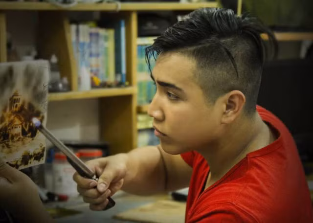 Tuấn đang vẽ tranh bằng lửa.