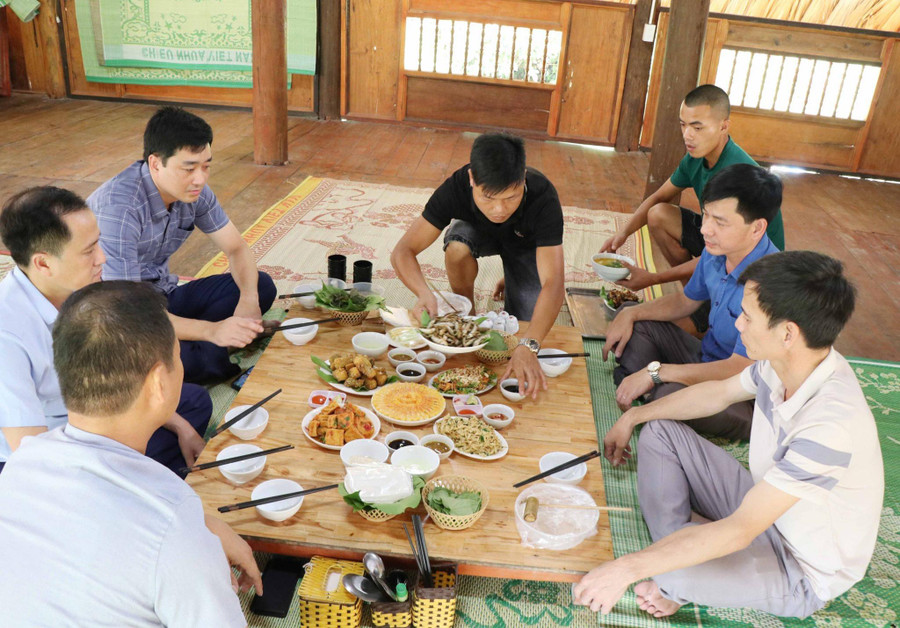 Anh Nguyễn Văn Tới (áo đen) người dân tộc Tày, chủ La Bằng homestay đang phục vụ các du khách tới thăm quan, trải nghiệm tại homestay.