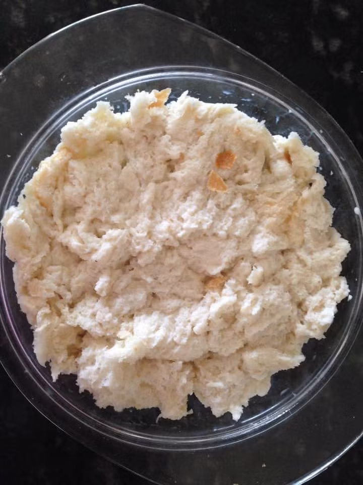 Ruột bánh mỳ xé nhỏ, tưới với 100ml sữa tươi cho mềm.