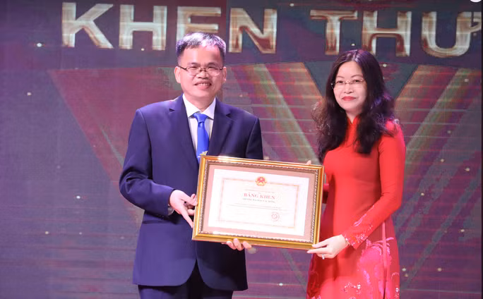 Đại diện Trường ĐH Lạc Hồng (bên trái) nhận bằng khen của Bộ GD&amp;ĐT.