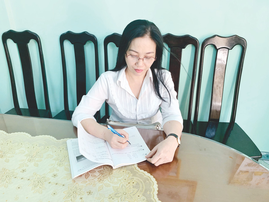 Tranh thủ giờ giải lao cô Dung sửa bài tập cho các em. Ảnh: Mạnh Tuấn