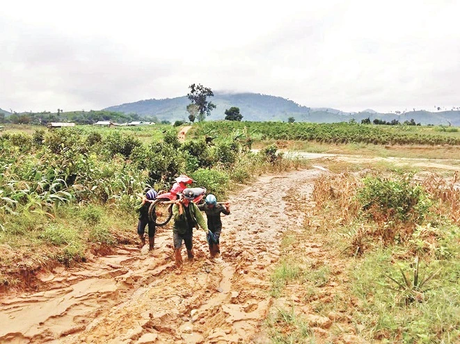 Vào mùa mưa, thầy cô phải vật lộn với con đường sình lầy, cõng xe đi bộ đến trường. Ảnh: Trúc Hân