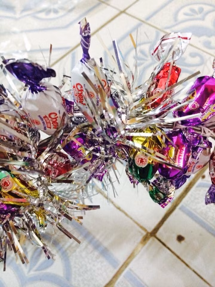 Lấy dây màu quấn xung quanh các khe hở, chú ý khoảng cách luồn dây có thể 2-3 cặp kẹo. Lấy dây màu quấn xung quanh các khe hở, chú ý khoảng cách luồn dây có thể 2-3 cặp kẹo.