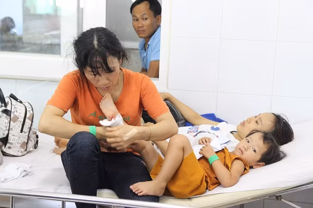 Chị Minh đang đang dỗ cháu nhỏ liên tục quấy khóc vì vết thương ở chân.