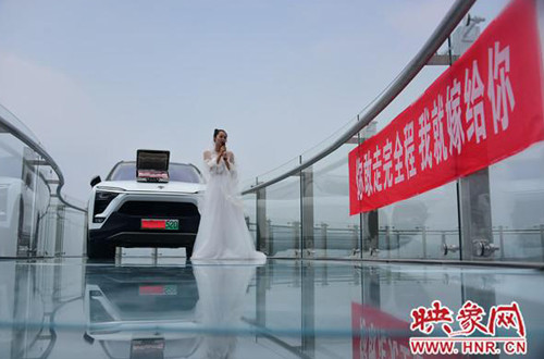 Ngày 15/8, tại cầu kính Fuxi Mountain Skywalk (nằm ở núi Phục Hy, Hà Nam), một cô gái đã thử thách người bạn trai sợ độ cao của mình. Cô mặc váy cưới, đứng trên cầu cùng chiếc xe ôtô mới cứng và một vali tiền trên mui xe. Cạnh cô là băng rôn:"Em sẽ kết hôn với anh nếu anh dám bước tới bên em". Ngày 15/8, tại cầu kính Fuxi Mountain Skywalk (nằm ở núi Phục Hy, Hà Nam), một cô gái đã thử thách người bạn trai sợ độ cao của mình. Cô mặc váy cưới, đứng trên cầu cùng chiếc xe ôtô mới cứng và một vali tiền trên mui xe. Cạnh cô là băng rôn:Em sẽ kết hôn với anh nếu anh dám bước tới bên em.