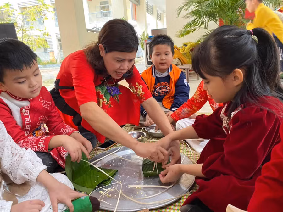 Cô giáo hướng dẫn học sinh cách gói bánh chưng. Cô giáo hướng dẫn học sinh cách gói bánh chưng.