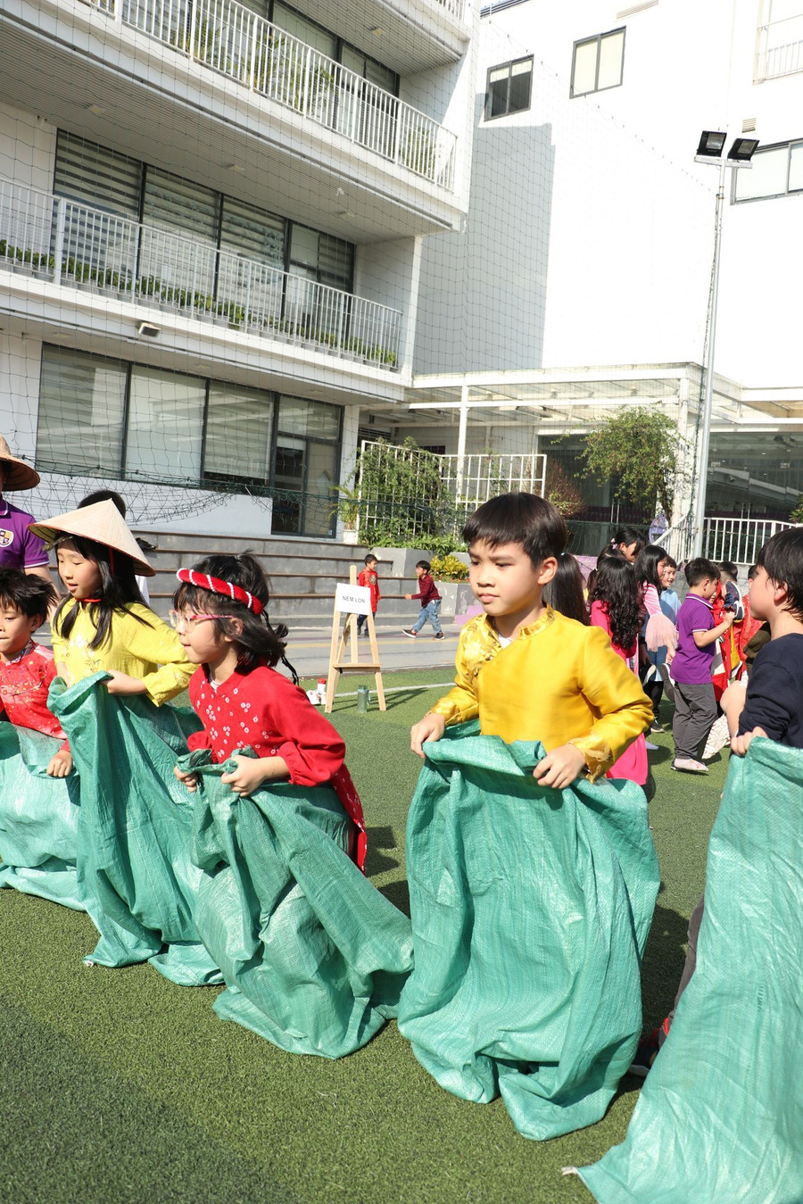 Trẻ tham gia chơi nhảy bao bố trong tiếng cổ vũ của bạn bè. Trẻ tham gia chơi nhảy bao bố trong tiếng cổ vũ của bạn bè.