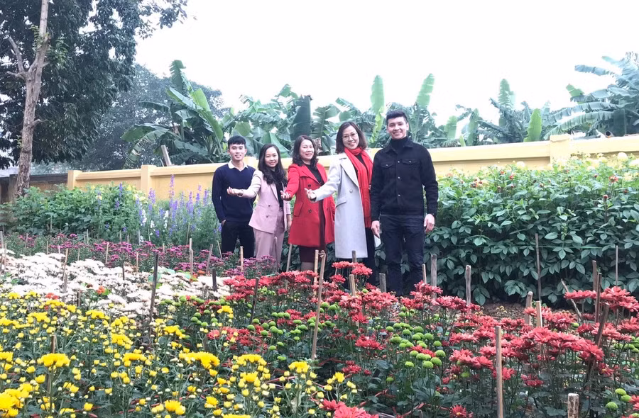 Các thầy cô bên vườn trường đầy hoa lá.