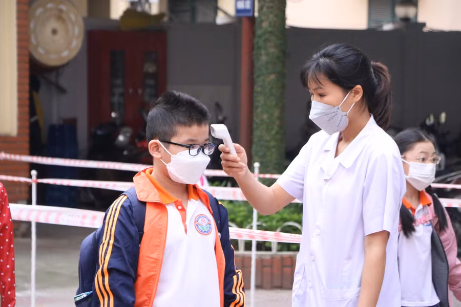 Học sinh Trường Tiểu học Trung Văn đo thân nhiệt, rửa tay sát khuẩn ngay từ cổng trường.