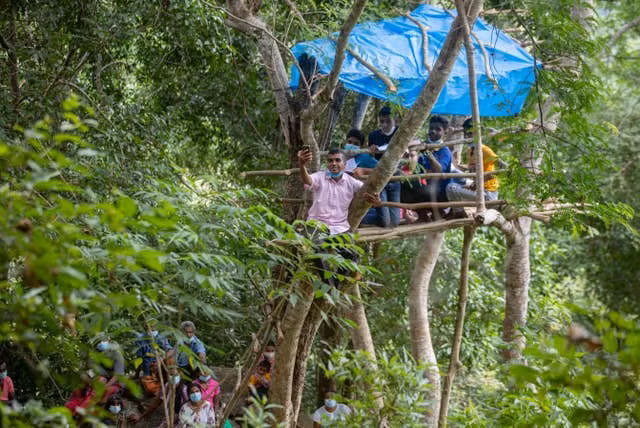 Giáo viên dùng điện thoại của mình để chia sẻ bài giảng cho nhóm 4 học sinh.