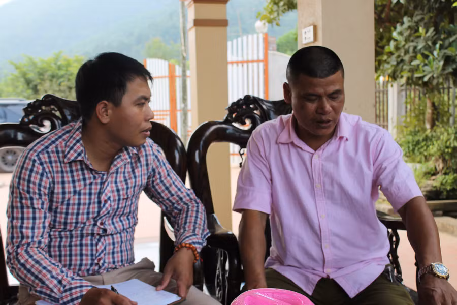 Ông Nguyễn Đình Cường, Trưởng thôn Minh Tân (bên phải)) trao đổi về những khó khăn, vất vả mà các em học sinh địa phương gặp phải khi đóng cửa Trường Tiểu học Minh Trí II